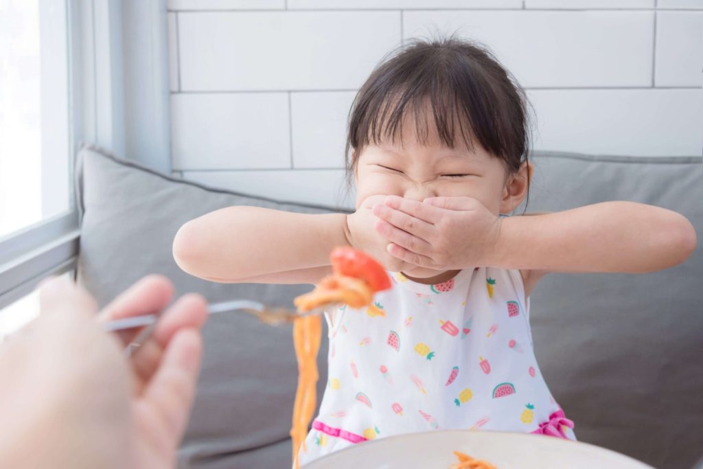 Picky-eater-girl-with-hands-over-mouth